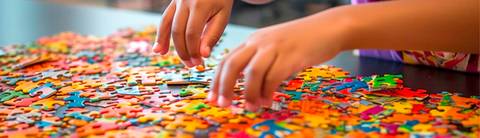 Un niño está armando un rompecabezas colorido sobre una mesa.