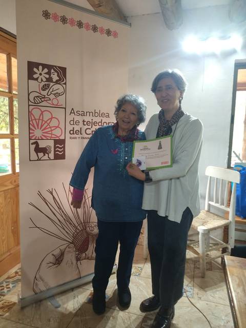 Dos mujeres sonrientes celebran en la Asamblea de Tejido del Cielo.