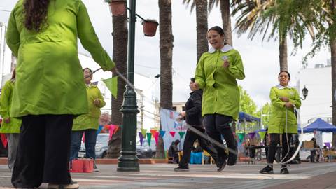 Un grupo de mujeres salta la cuerda en una plaza, disfrutando de una jornada al aire libre.
