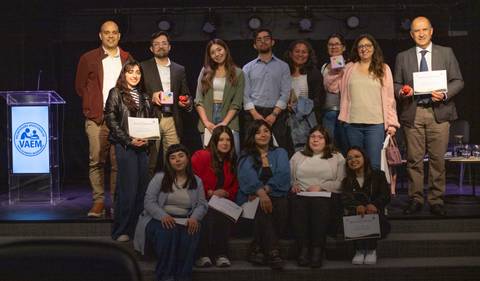 Un grupo de personas posando felices tras recibir reconocimientos en un evento.