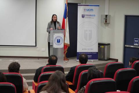 Una persona está dando una charla en un auditorio universitario.