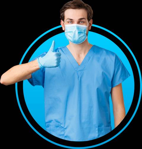 Un profesional de la salud sonríe mientras levanta el pulgar, vistiendo una mascarilla y guantes azules.