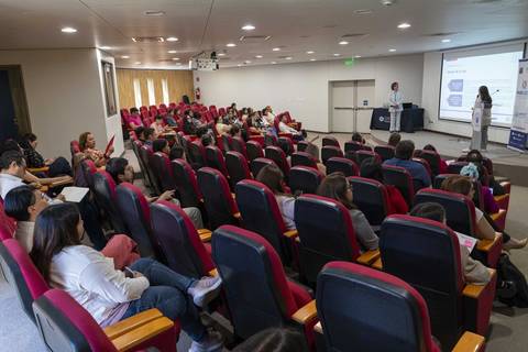 Una presentación educativa en un auditorio con muchas personas atentos.