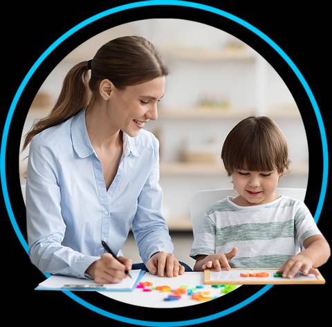 Una mujer sonríe mientras ayuda a un niño a jugar con piezas de un juego en una mesa.