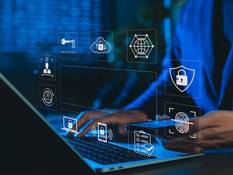 Un profesional interactuando con tecnología de seguridad cibernética frente a una computadora.