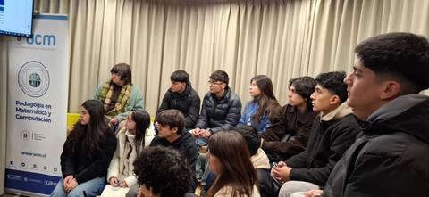 Un grupo de adolescentes escucha atentamente una presentación sobre pedagogía en matemáticas y computación.
