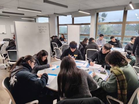 Un grupo de estudiantes trabajando en equipo en un salón de clases.