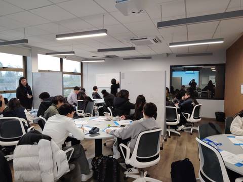 Una sala de clases llena de estudiantes en una actividad colaborativa.
