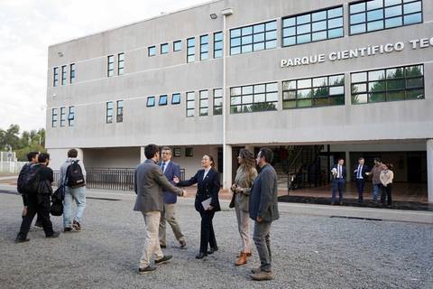 Un grupo de profesionales se saludan frente al Parque Científico y Tecnológico.