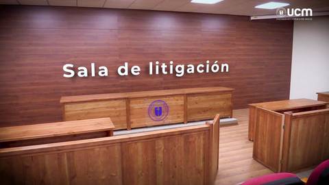 Una sala de litigación con mobiliario de madera y un panel de pared con el texto 'Sala de litigación'.