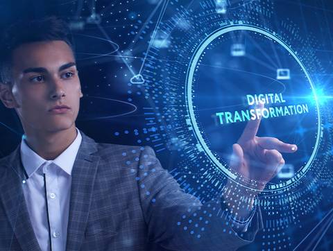 Un joven en traje interactuando con una representación digital sobre transformación digital.