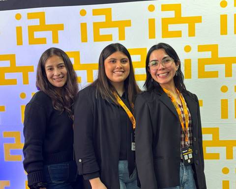 Tres amigas posando juntos con una sonrisa en un evento.