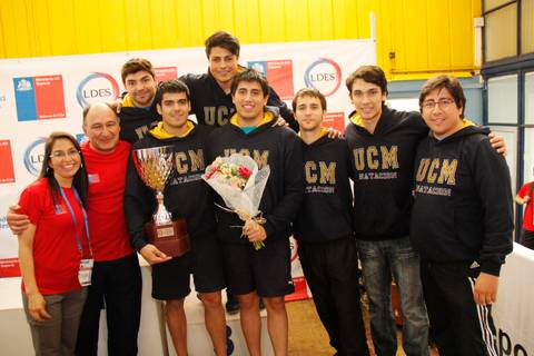 Equipo de deportistas posando con un trofeo y una celebración tras ganar un campeonato.