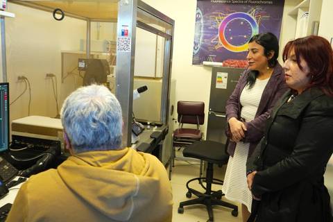 Un grupo de personas observa una presentación en un laboratorio con equipos científicos.