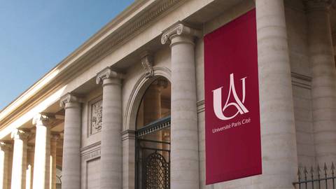 Una fachada imponente de la Universidad París Cité con columnas y un gran banner rojo.