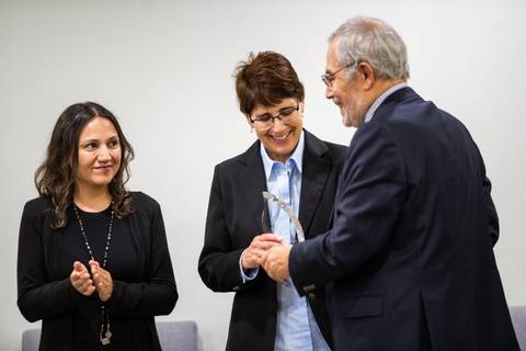 Un grupo de personas celebrando un reconocimiento en un evento formal.