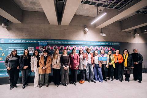 Un grupo de mujeres celebra el viaje de ser ingenieras en un evento con una gran pancarta de fondo.