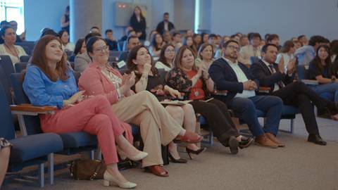 Un grupo de personas aplaudiendo en un evento o conferencia.
