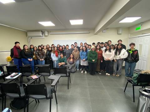 Un grupo grande de estudiantes posando en un aula.