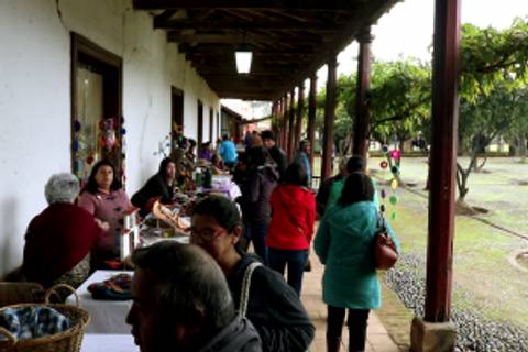 Una feria de artesanías con diversas personas disfrutando del ambiente.