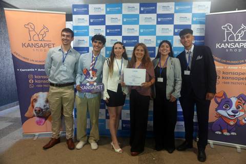 Un grupo de jóvenes posando felices con un diploma en un evento de Kansapet.