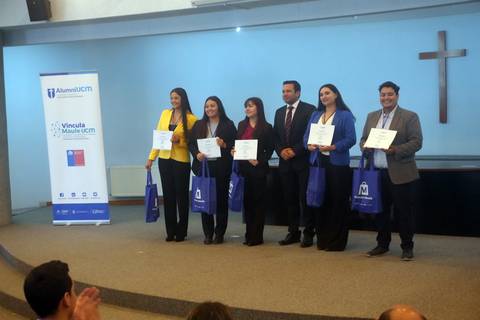 Un grupo de personas sostiene sus certificados en un evento de graduación en Chile.