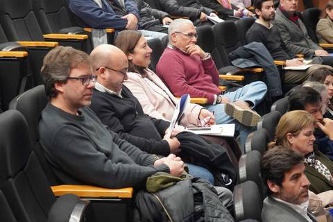 Un grupo de personas sentadas en un auditorio escuchando atentamente una charla.