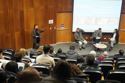 Un panel de discusión en una sala con público atento en una universidad chilena.