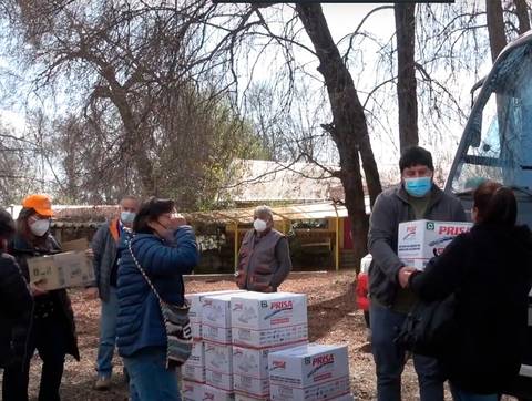 Distribución de cajas de alimentos entre la comunidad en un ambiente solidario.