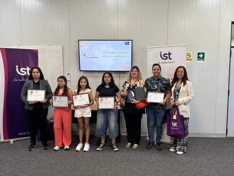 Un grupo de personas sonrientes sosteniendo certificados en un evento de premiación.