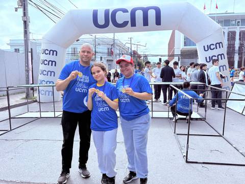 Un grupo de tres personas sonrientes posando en un evento deportivo de la UCM.