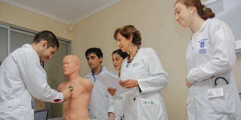 Un grupo de personas está practicando una técnica médica en un maniquí en un entorno clínico.
