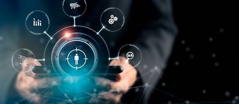 Una persona sostiene un dispositivo móvil con iconos de tecnología y análisis de datos en el fondo.
