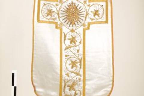 Se trata de un estandarte religioso decorado con bordados dorados y un diseño floral.