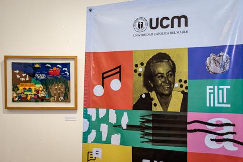 En la imagen se observa un cuadro artístico al lado de un banner de la Universidad Católica del Maule.