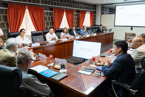 Una reunión de trabajo con varios asistentes en una sala equipada.