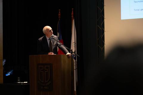 Un hombre está dando una presentación frente a un auditorio oscuro.