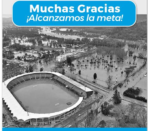 La imagen muestra un estadio rodeado de agua debido a una inundación.