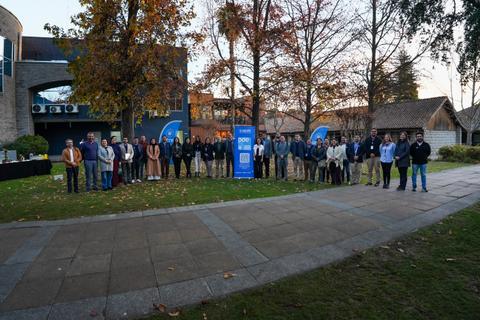 Un grupo de personas posando al aire libre durante un evento en un entorno natural.