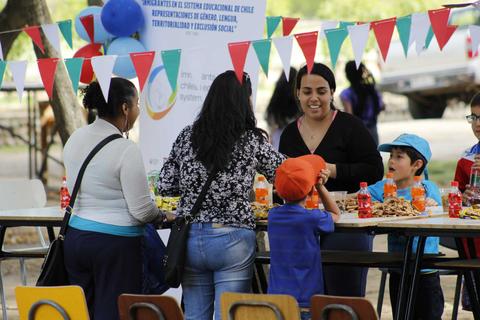 Un grupo de personas disfrutando de una reunión al aire libre con comida y bebida.