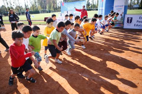 Un grupo de niños está a punto de comenzar una carrera en una pista de tierra.