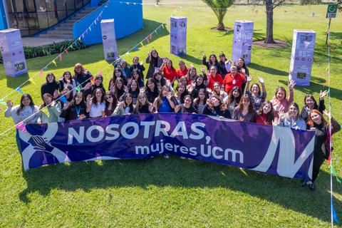 Un grupo de mujeres sonrientes se reúne para celebrar la diversidad y el empoderamiento en un evento al aire libre.