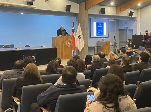Un seminario en Santiago con un orador frente a una audiencia atenta.