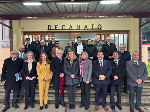 Grupo de profesionales posando en la entrada del Decanato en un día nublado.