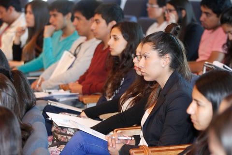 Un grupo de estudiantes escuchando atentamente en un aula.