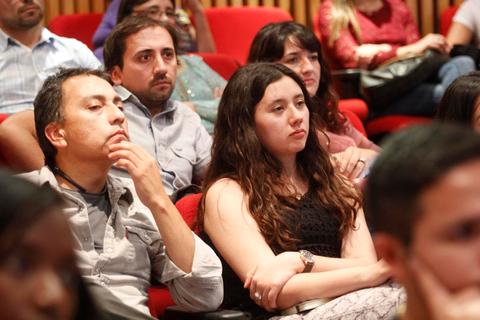 Un grupo de personas sentadas en una audiencia durante un evento.