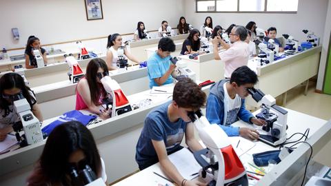 Un grupo de estudiantes en un laboratorio realizando prácticas con microscopios.