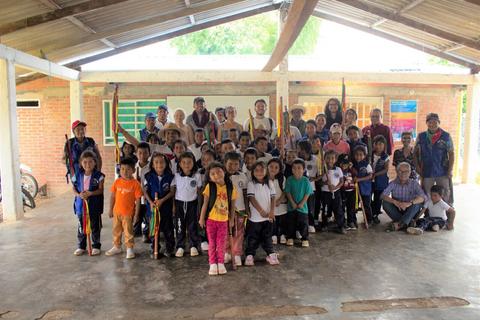 Un grupo de niños y adultos posando juntos en un edificio escolar.