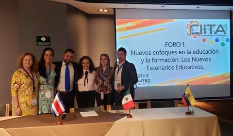 Un grupo de personas sonríen frente a una presentación sobre nuevos enfoques en educación y formación.