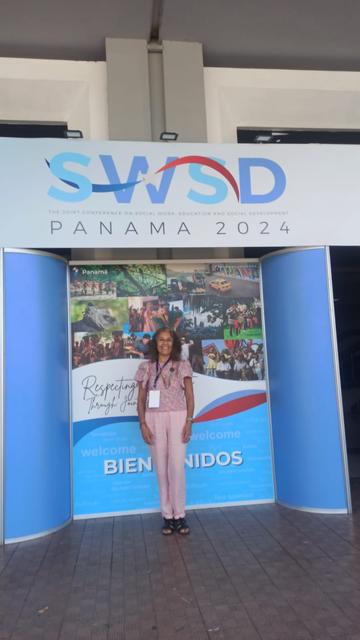 Una persona posa en un evento con un cartel que dice SWSD PANAMA 2024.